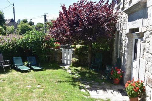 einen Hof mit Stühlen und einen Baum mit roten Blättern in der Unterkunft Maison paysanne, proche Aubrac in Huparlac