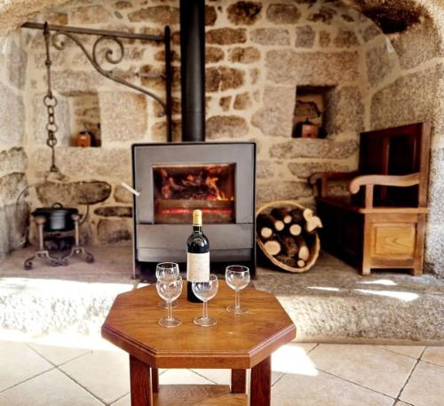einen Tisch mit zwei Weingläsern und einem Kamin in der Unterkunft Maison paysanne, proche Aubrac in Huparlac