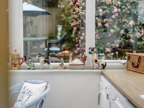a window with figurines of cats and a chicken on a counter at 2 bed in Bexhill on Sea 82747 in Sidley