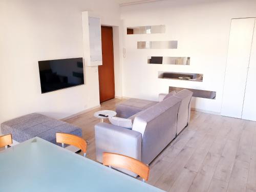 sala de estar con sofá y TV en Your Spacious & Lovely home -2 queen bed, 2 large single beds-, en Milán