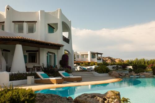 une villa avec une piscine à côté d'une maison dans l'établissement Romazzino, A Belmond Hotel, Costa Smeralda, à Porto Cervo