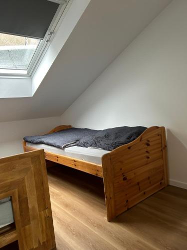 Cama de madera en habitación con ventana en Moderne Service Apartment / Ferienwohnung, en Recklinghausen
