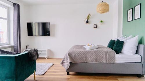 ein Schlafzimmer mit einem Bett und einem TV an der Wand in der Unterkunft SH-Apartment Petra *zentral & stilvoll* in Erfurt