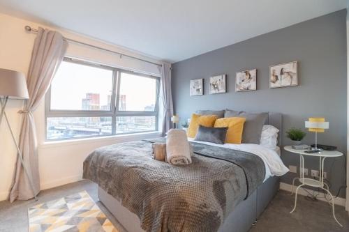 een slaapkamer met een groot bed en een raam bij Luxury Riverview City Centre Apartment 2 in Glasgow
