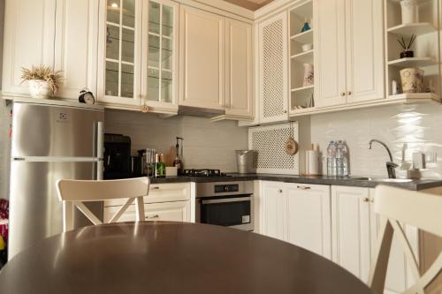 cocina con armarios blancos y encimera negra en Beautiful, spacious apartment! Free Private Parking, en Riga