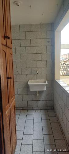 ein Bad mit einem Waschbecken an einer gefliesten Wand in der Unterkunft Apartamento Bela Vista in Rio das Ostras