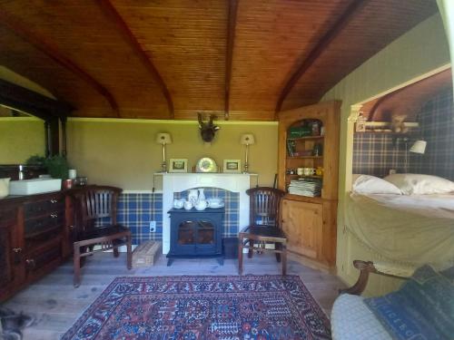 a bedroom with a bed and a fireplace with two chairs at Home Bij Zee in Koudekerke