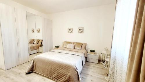 Habitación blanca con cama y sofá en Appartamento vicino al centro Adigeo e fiera en Verona