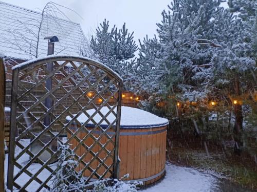 LipuszにあるKaszuby wczasy u Danusi sauna i baniaの雪に覆われた庭園(ホットタブ、木付)