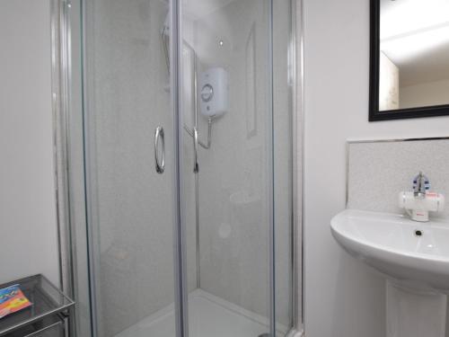 a shower with a glass door next to a sink at 3 Bed in North Uist 77239 in Sollas