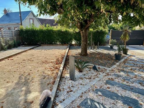 un parco con un albero e una panchina in un cortile di La Longère du menuisier a Romorantin