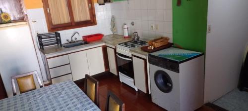 a kitchen with a stove and a washing machine at SantaTeresita in Santa Teresita