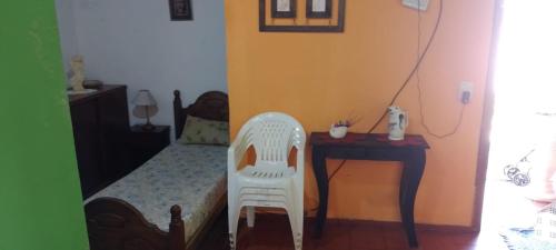 1 dormitorio con 1 cama con silla y escritorio en SantaTeresita en Santa Teresita