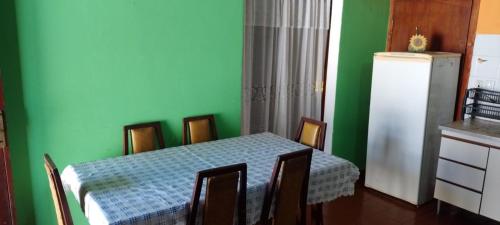 1 dormitorio con paredes verdes, mesa y sillas en SantaTeresita en Santa Teresita