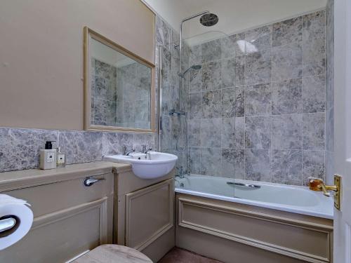 a bathroom with a sink and a tub and a mirror at 1 bed in Kirkby Fleetham 82336 in Kirkby Fleetham