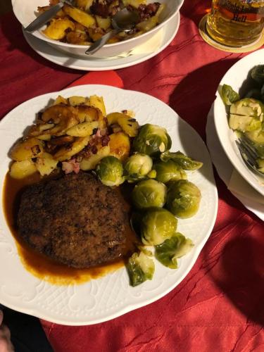 a plate of food with meat and vegetables on a table at Hotel-Restaurant Denklinger-Hof in Reichshof 