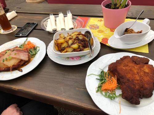 a wooden table with plates of food on it at Hotel-Restaurant Denklinger-Hof in Reichshof 