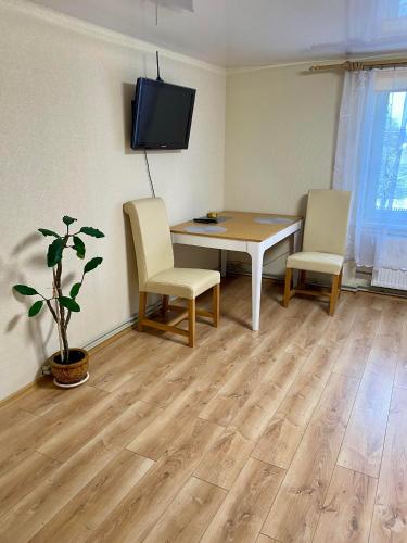 Cette chambre dispose d'une table, de deux chaises et d'une télévision. dans l'établissement Butas S. Daukanto gatvėje, à Telšiai