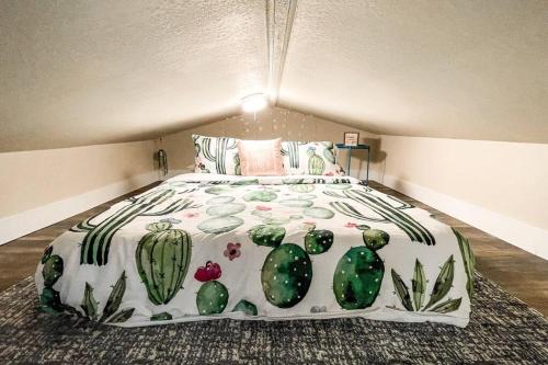 a bedroom with a large bed with cactus sheets at Stylish remodeled studio near IvyWild/Downtown in Colorado Springs