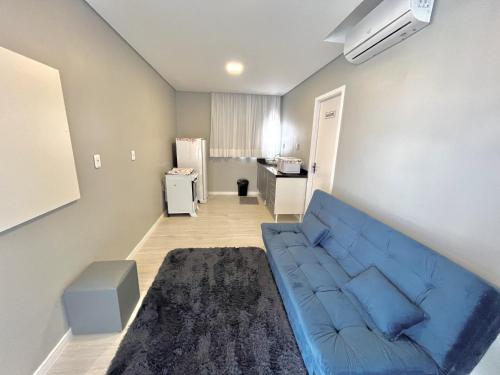 a living room with a blue couch and a kitchen at Hotel Manaus - Dom Pedro I in Manaus