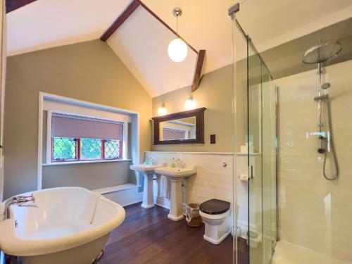 a bathroom with a tub and a sink and a shower at Daweswood, Patterdale in Patterdale