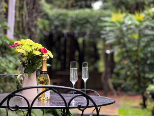 a table with two champagne glasses and a vase with flowers at Daweswood, Patterdale in Patterdale