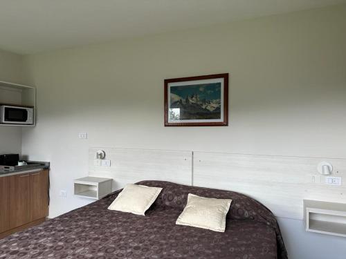 a bedroom with a bed and a picture on the wall at Fitz Roy Hostería de Montaña - El Chaltén in El Chalten