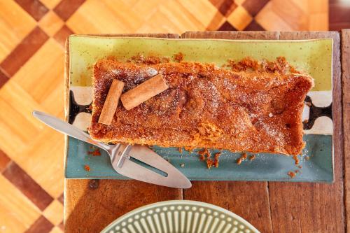 a piece of cake on a blue plate with cinnamon sticks at Gerthrudes Bed & Breakfast in Rio de Janeiro
