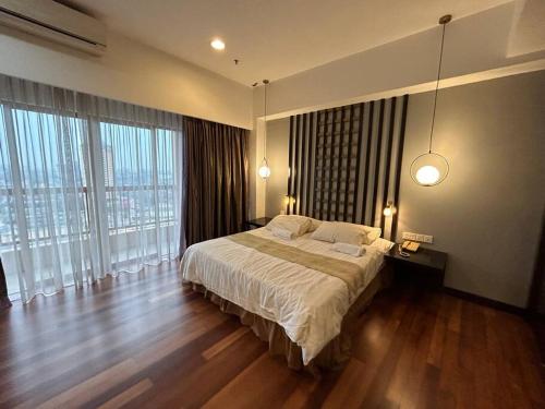 een slaapkamer met een groot bed en grote ramen bij New-SunwayLagoonFamilySuite-highest floor-2-4pax-Netflix-Balcony-SuperFastInternet in Petaling Jaya