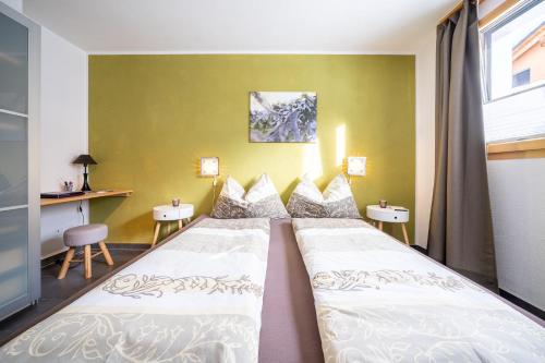 a hotel room with two beds and a window at Chasa Sotchà Dadora 698 in Scuol