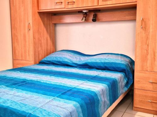 - un lit avec une couette bleue dans une chambre dans l'établissement **BANYULS-SUR-MER: T2 avec terrasse, entre plages, randonnées, et activités nautiques !** - FR-1-309-413, à Banyuls-sur-Mer