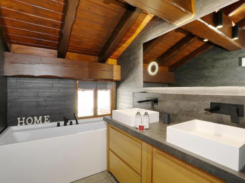 a bathroom with two sinks and a bath tub at Chalet La Tania, 6 pièces, 10 personnes - FR-1-575-202 in Courchevel