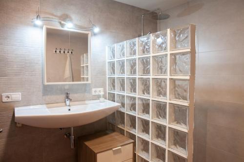 W łazience znajduje się umywalka i lustro. w obiekcie Ca La Remei i Can Benet w mieście Els Hostalets d'en Bas