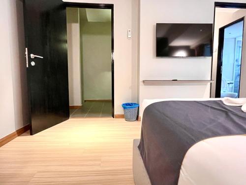 a bedroom with a bed and a black door at HillMark Suites in Ayer Keroh