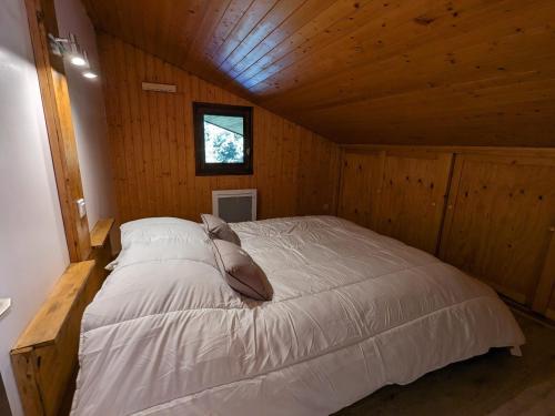 une chambre avec un lit dans une cabane en bois dans l'établissement Duplex cosy au pied des pistes avec garage - La Clusaz - FR-1-459-223, à La Clusaz