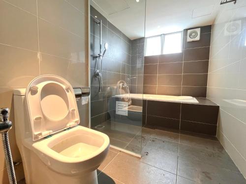 a bathroom with a toilet and a shower and a sink at HillMark Suites in Ayer Keroh