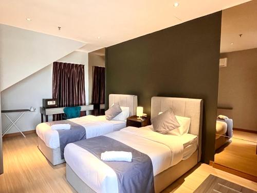 a hotel room with two beds in a room at HillMark Suites in Ayer Keroh