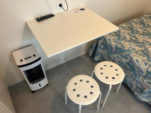 a table and two chairs next to a bed at El descanso de Lucía, estudio in Conil de la Frontera