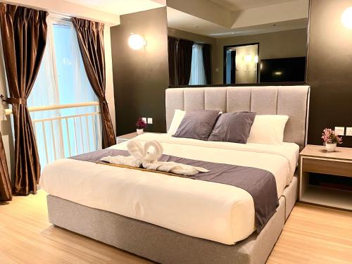 a bedroom with a large bed with two towels on it at HillMark Suites in Ayer Keroh