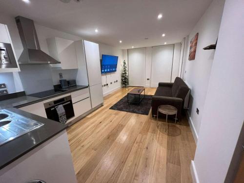 a living room with a couch and a kitchen at Impeccable 2-Bed Apartment in Erith in Erith