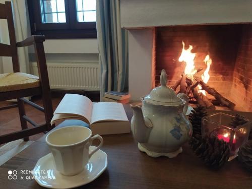 a table with a tea pot and a book next to a fireplace at Esperos Suites & Villas in Lafkos
