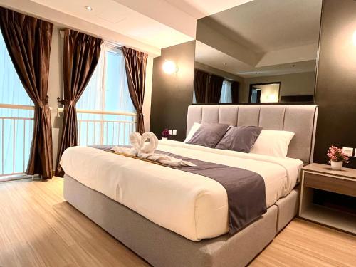 Un dormitorio con una cama grande con un animal de peluche encima. en HillMark Suites, en Ayer Keroh