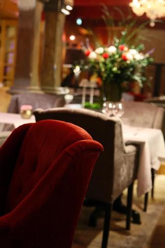 a dining room with a table with a vase of flowers at La Villa Mazarin in Aigues-Mortes