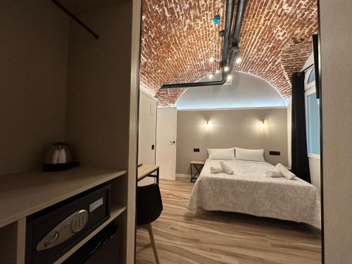 a bedroom with a bed and a brick wall at CC Opera Suites in Madrid