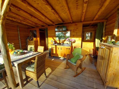 un porche de una cabaña con mesa y sillas en Home Bij Zee, en Koudekerke