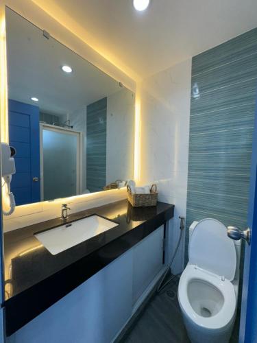 a bathroom with a toilet and a sink and a mirror at EliJosh Resort and Events Place in Silang