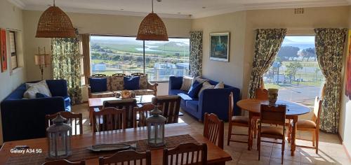 uma sala de estar com um sofá azul e uma mesa em Kleinmond Panorama Holidays em Kleinmond