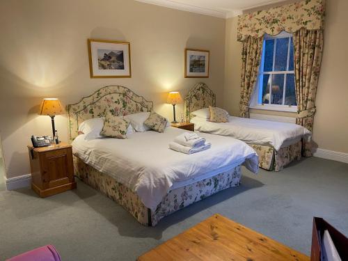 a bedroom with two beds and a window at Delphi Lodge in Leenaun