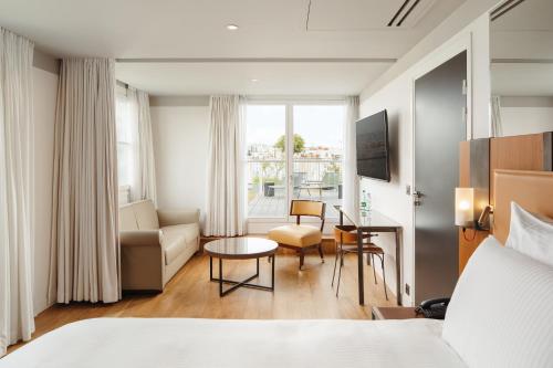 a hotel room with a bed and a living room at Boutet Bastille Hotel Paris - MGallery Collection in Paris