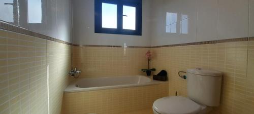 een badkamer met een toilet en een bad bij Casa el Hierro in Lajares